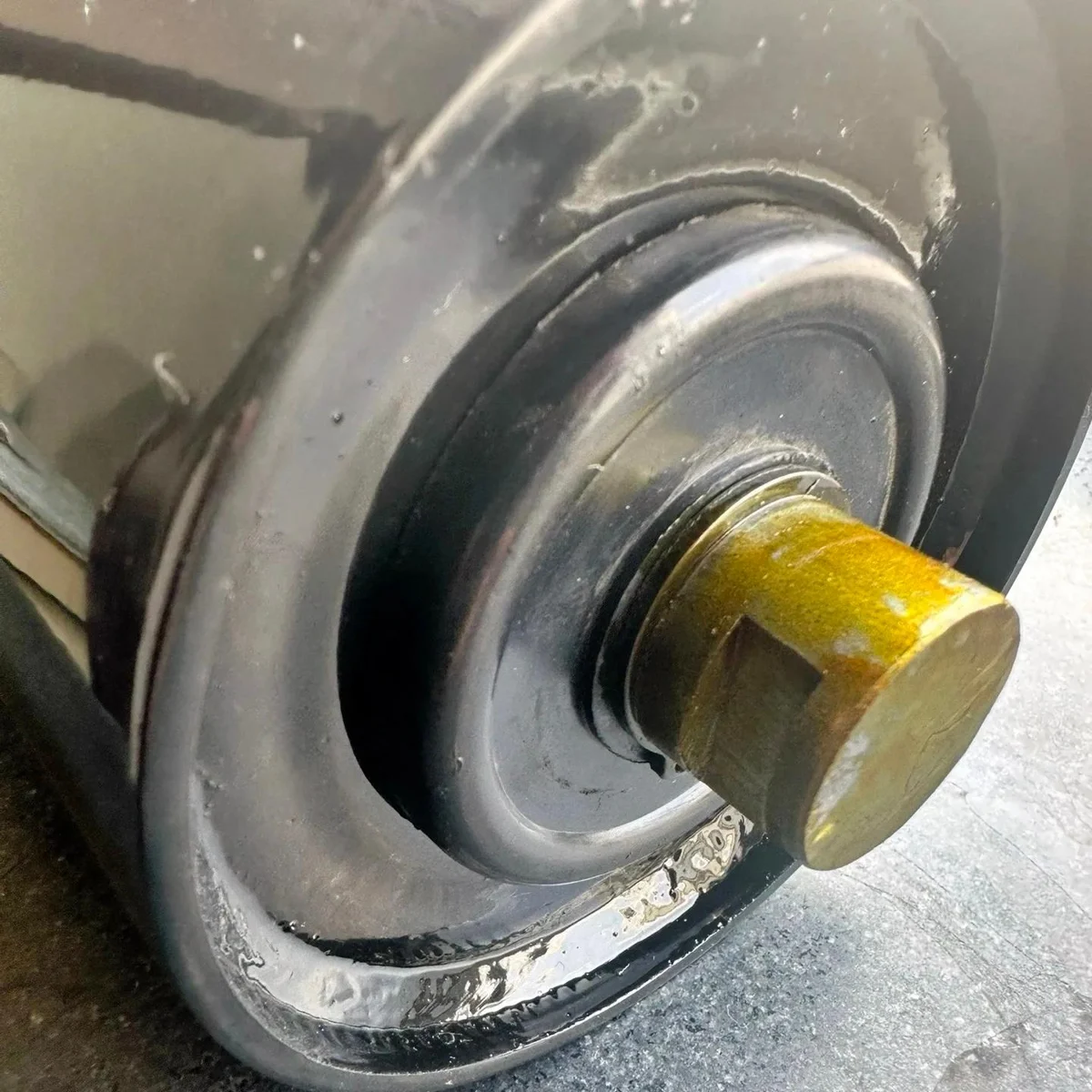 Close view of a roller shaft projecting from the end assembly